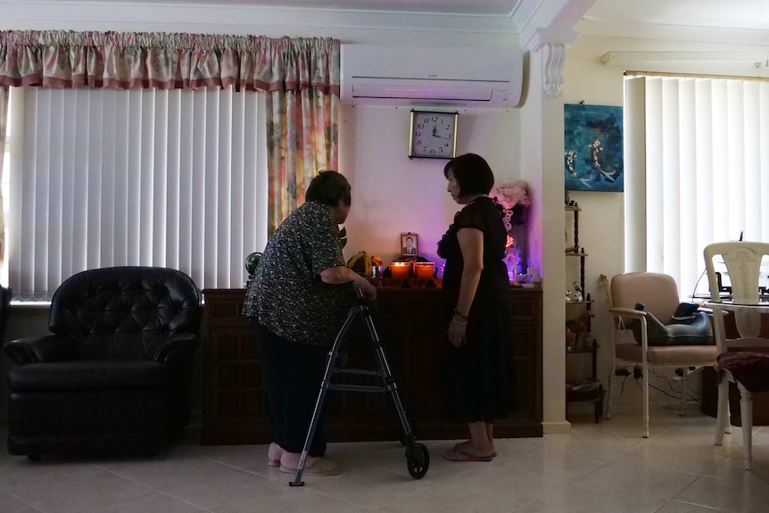 Two women around a shrine.