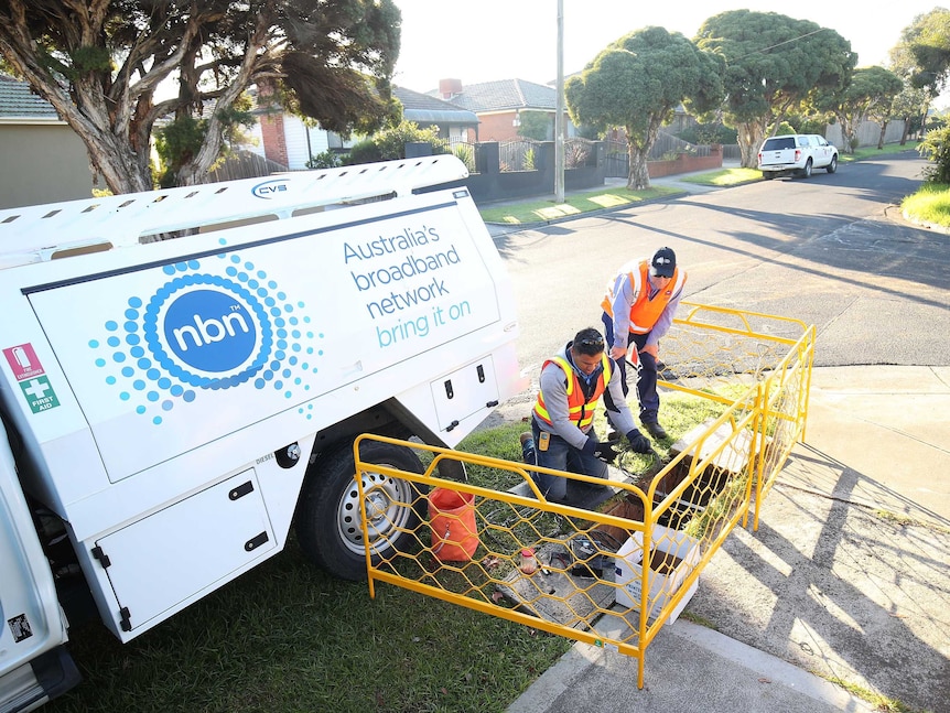 Workmen on a pavement installing NBN infrastructure.