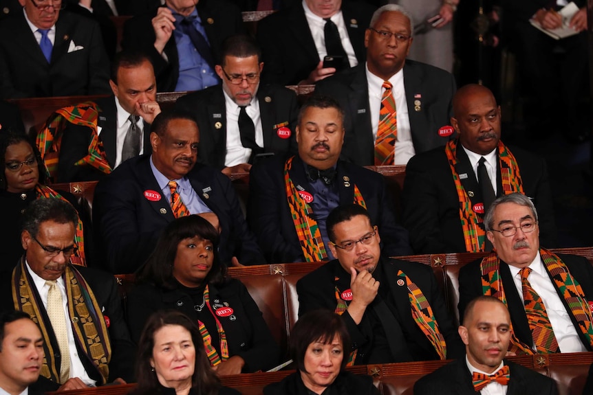 Democratic members of Congress look unimpressed as they listen to Mr Trump's state of the union speech