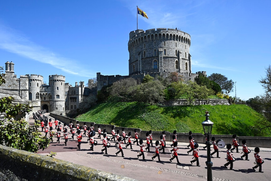 On a clear day, you view Grenadier Guards march in two rows down a path in front of Windsor Castle's round tower.