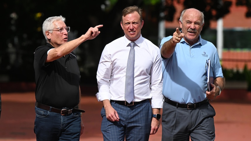 three men walking while pointing in front of suncorp stadium