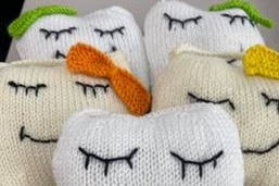 Little cushions in the shape of a tooth with smiles, eyelashes and ribbons