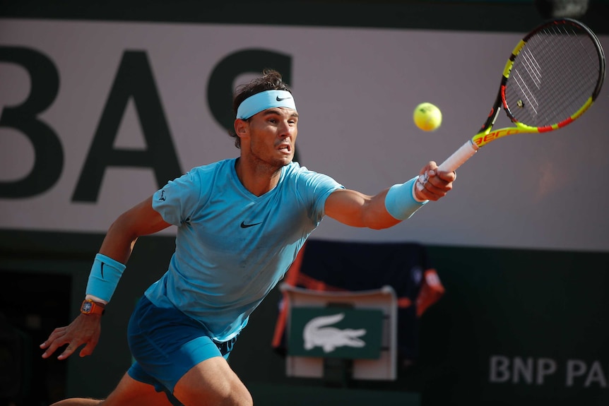 Rafael Nadal stretches to get his racquet to a ball.