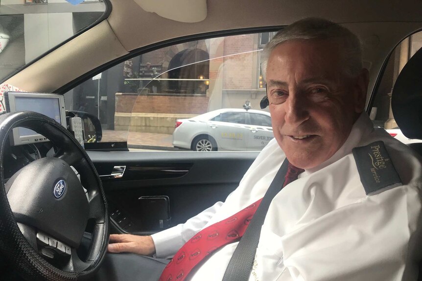 Geoff Williamson sits in the driver's seat of his taxi.