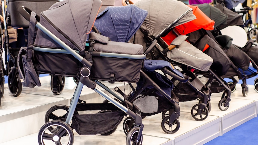 A row of new prams in a shop.