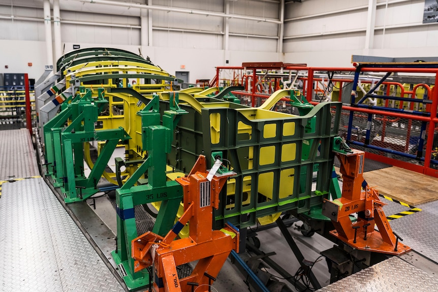 Un marco de metal verde y amarillo que forma el interior de un avión.