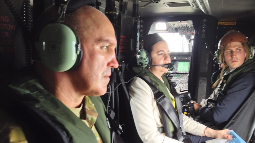 Brigadier Chris Field sits with Premier Annastacia Palaszczuk (centre) in a helicopter