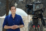 Former Europe correspondent James Glenday stands in front of a camera reporting from the Mati fires near Athens, Greece. 