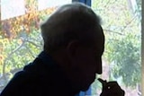 A silhouette of an older man sitting down looking thoughtful