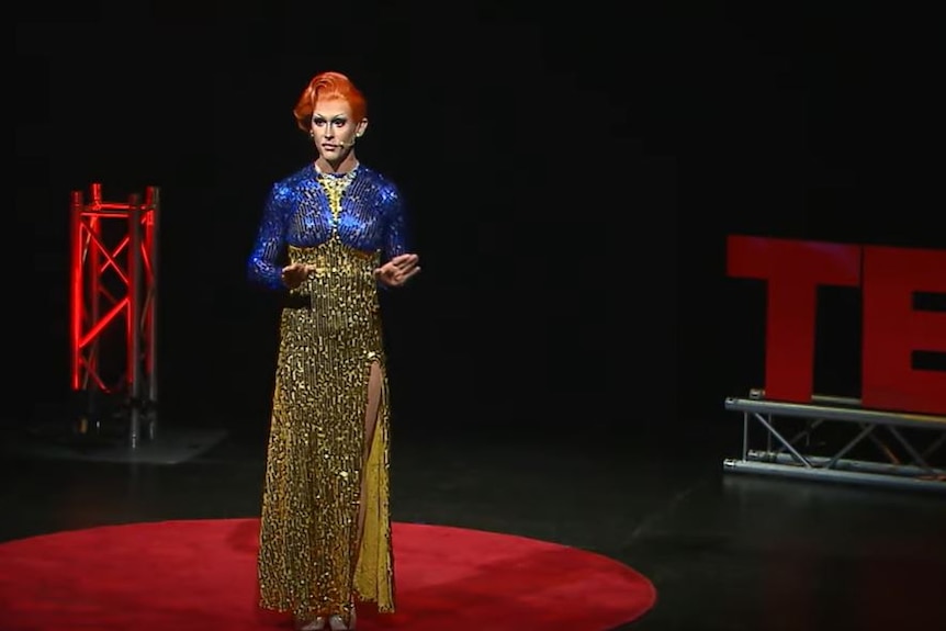 A drag performer stands on stage 