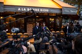 Managers of the bar deliver a press conference in front of the cafe during the reopening.