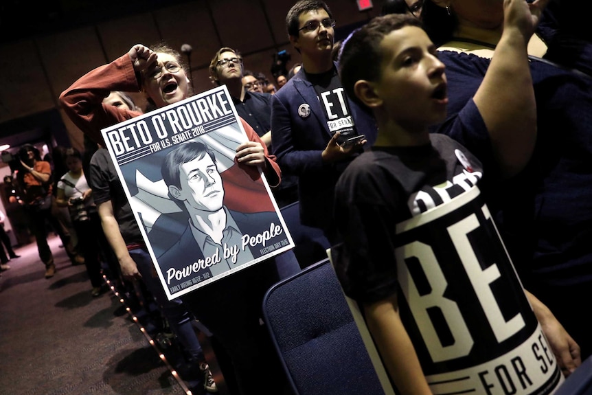 Supporters of Beto O'Rourke, then candidate for US Senate in November 2018, hold posters and cheer.