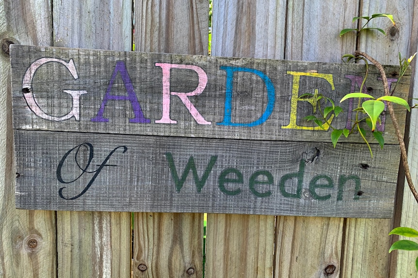 Wooden colourful sign saying "Garden of Weeden" 