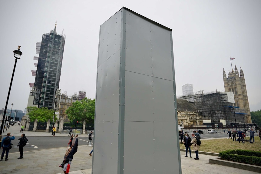 Pale grey hoarding covers the statue of Winston Churchill.