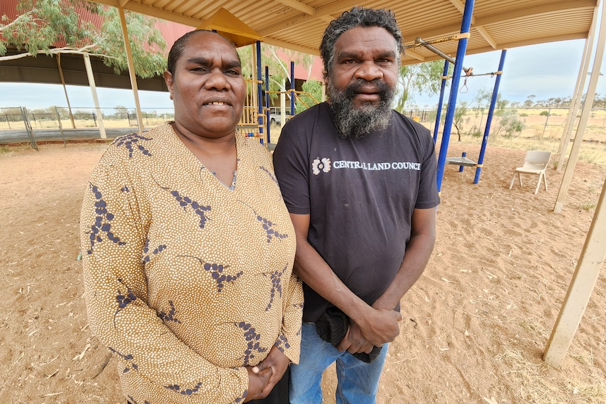 indigenous woman and indigenous man standing in children's playground