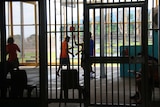 A small group of young men playing basketball on a court inside Darwin's Don Dale youth detention centre, 2017.