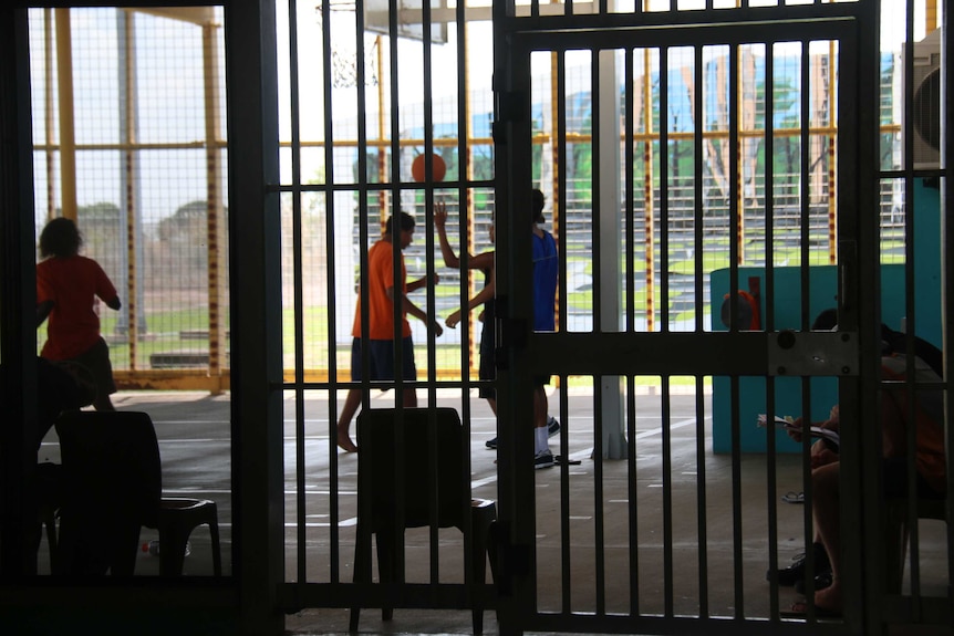 A small group of young men playing basketball on a court inside Darwin's Don Dale youth detention centre, 2017.