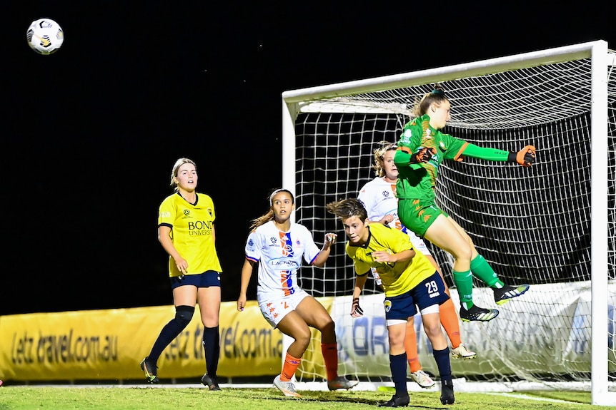 Holly McQueen watches the ball as it is punched away by the goalkeeper