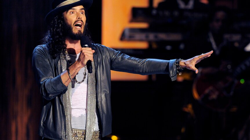 Comedian Russell Brand performs on stage. 