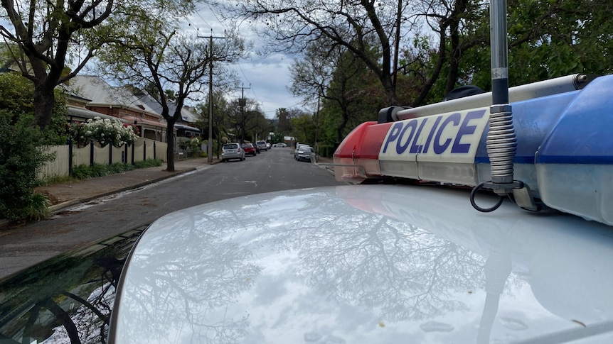 A police car parked blocking off a suburban street