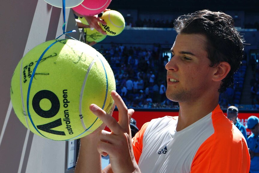 Dominic Thiem signs tennis balls at Australian Open