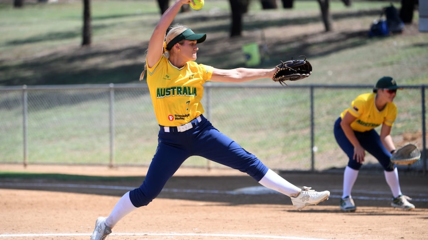 an Australian softball pitcher winds up before delivering a pitch