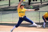 an Australian softball pitcher winds up before delivering a pitch