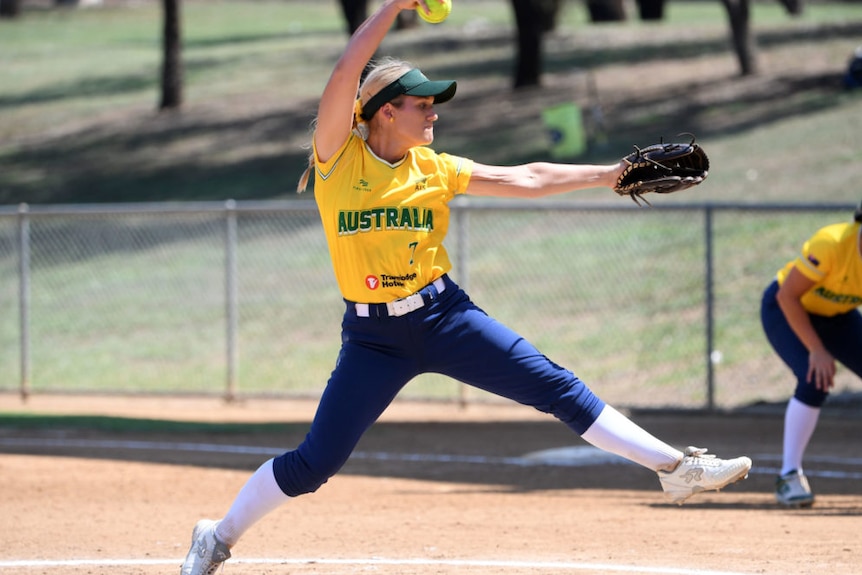 an Australian softball pitcher winds up before delivering a pitch