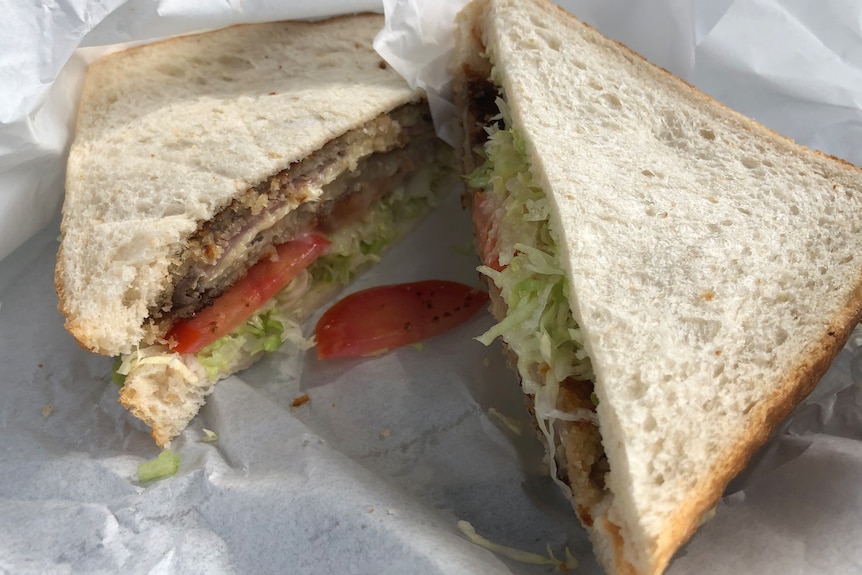 A sandwich with steak, tomato and lettuce.