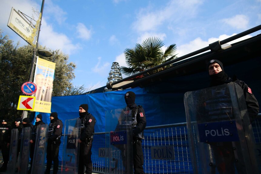 Turkish police officers stand guard outside a nightclub which was attacked by a gunman overnight in Istanbul
