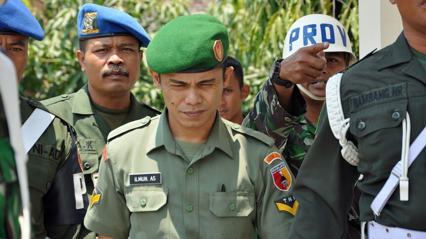 Sergeant Ilmun Abdul Said (C) of the Indonesian army is escorted to court in Madiun, East Java on September 24, 2012.