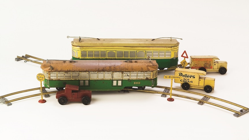 An old toy tram set, complete with tracks and carriages, signs and cars.