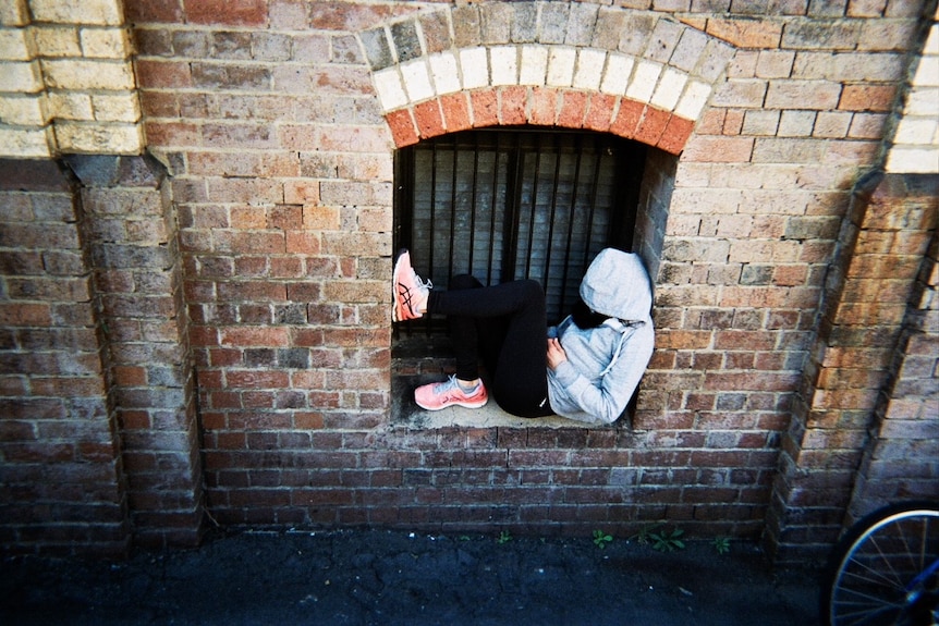 Person sleeping in an alcove during the day.