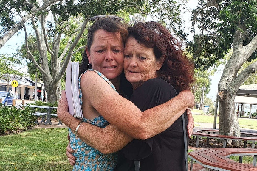 Shae Francis's mother and aunty hug each other in a park