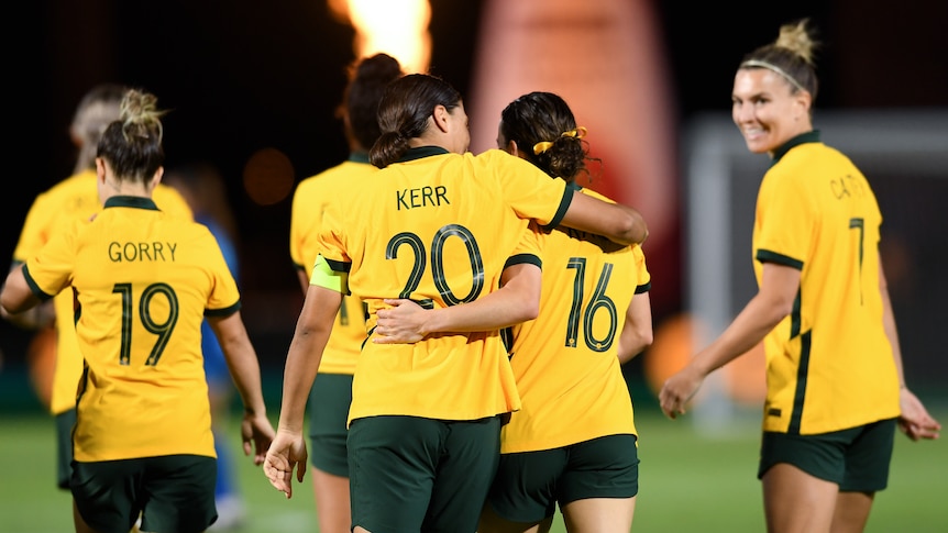 Sam Kerr and Hayley Raso put their arms around each other as they walk away from camera during a Matildas match.