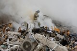 A fireman walks through rubble and debris from the fallen building.