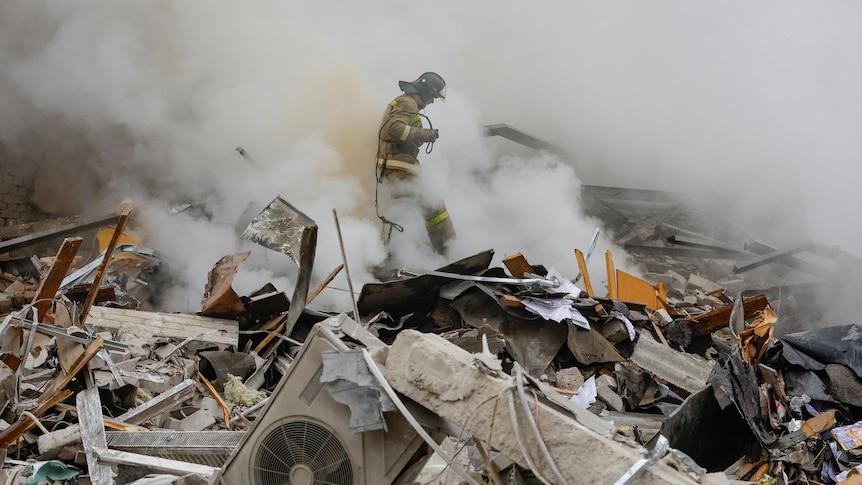 A fireman walks through rubble and debris from the fallen building.