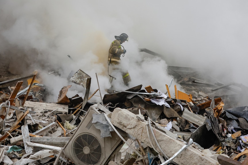 A fireman walks through rubble and debris from the fallen building.