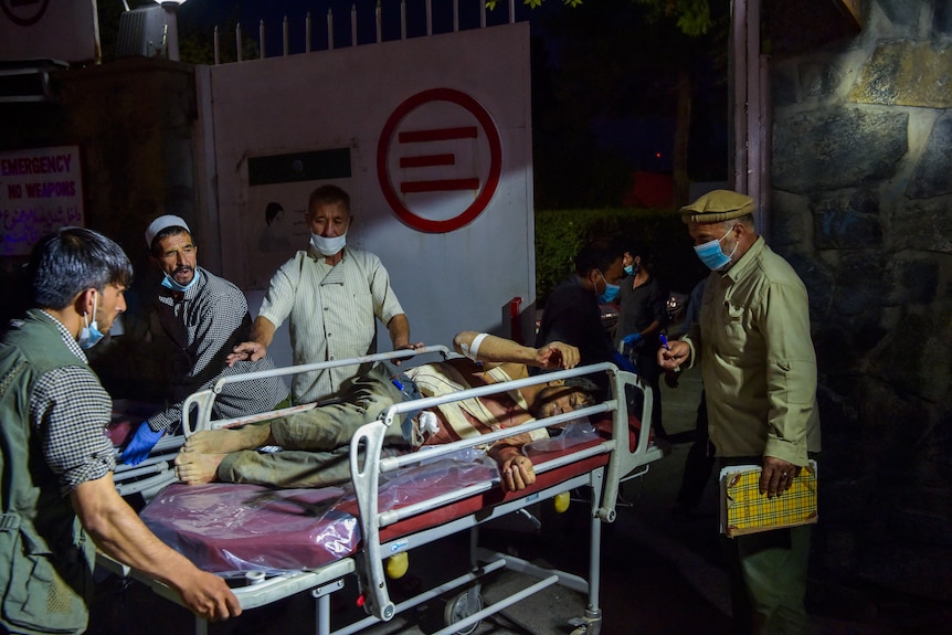 Hospital staff bring an injured man on a stretcher for treatment