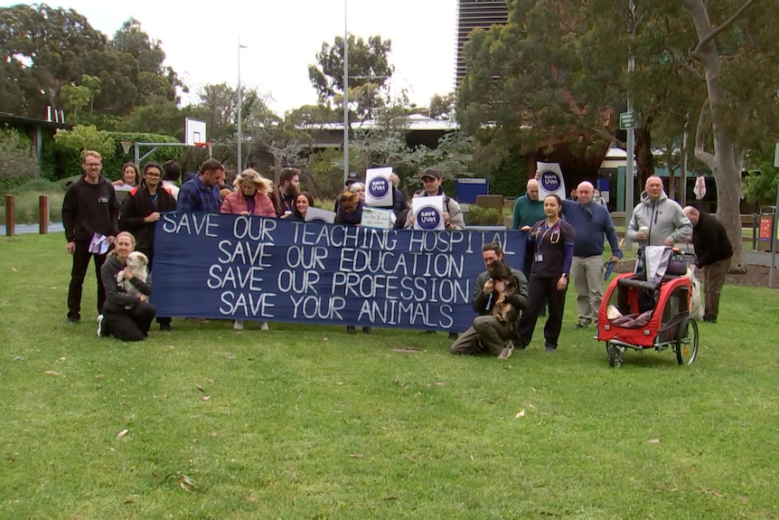 Workers and pets with a sign that says "save our teaching hospital, save our education, save our profession, save your animals"