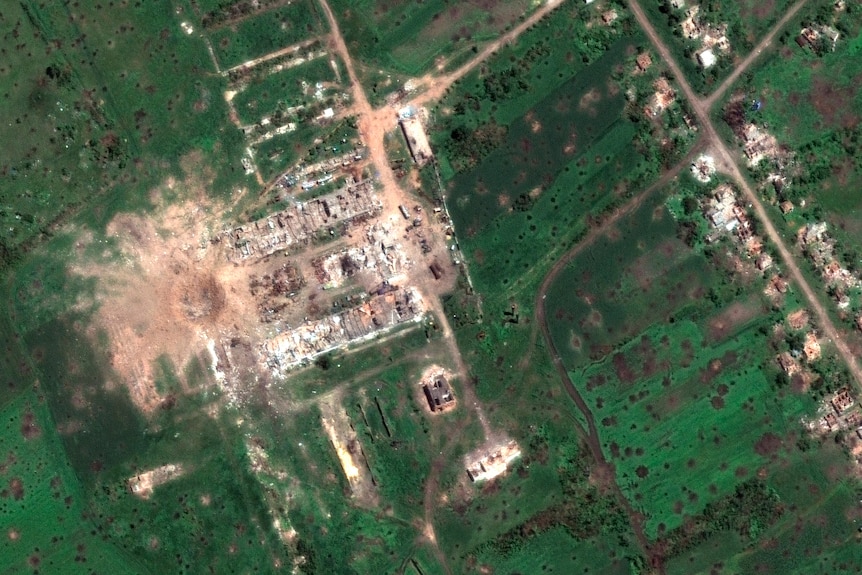 A satellite image of a huge crater seen on the edge of a town.