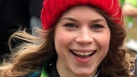 sarah everard smiles and holds a medal.