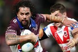 Josh Aloiai runs with the ball for Manly Sea Eagles as a St George Illawarra Dragons player tries to tackle him in an NRL game.