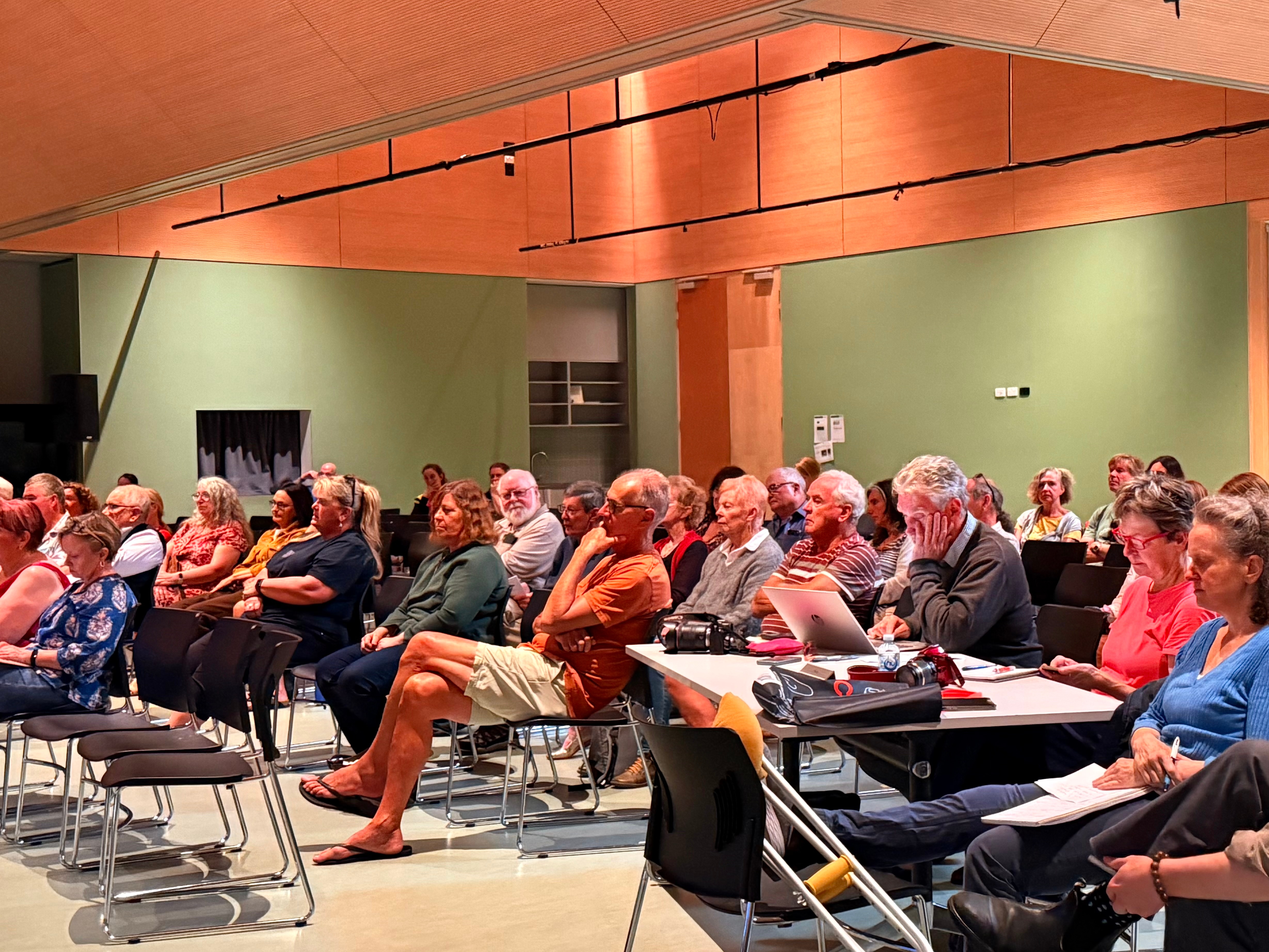 Image of a room packed with people sitting in the audience.