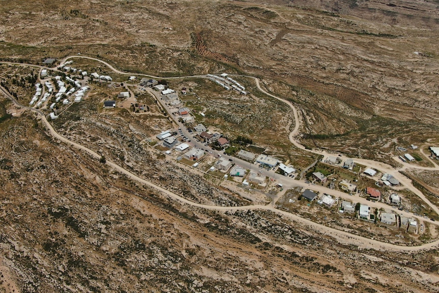 A drone shot of a small cluster of houses in an arid environment