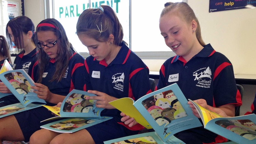 Calwell Primary School students read through the work-book on bullying and disability.