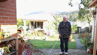 Paul Watkins displays the use of his white cane and how it has benefited his eyesight.