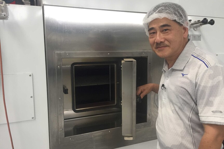 Ian Chow opens the door to his oven at his biscuit factory in Papua New Guinea.