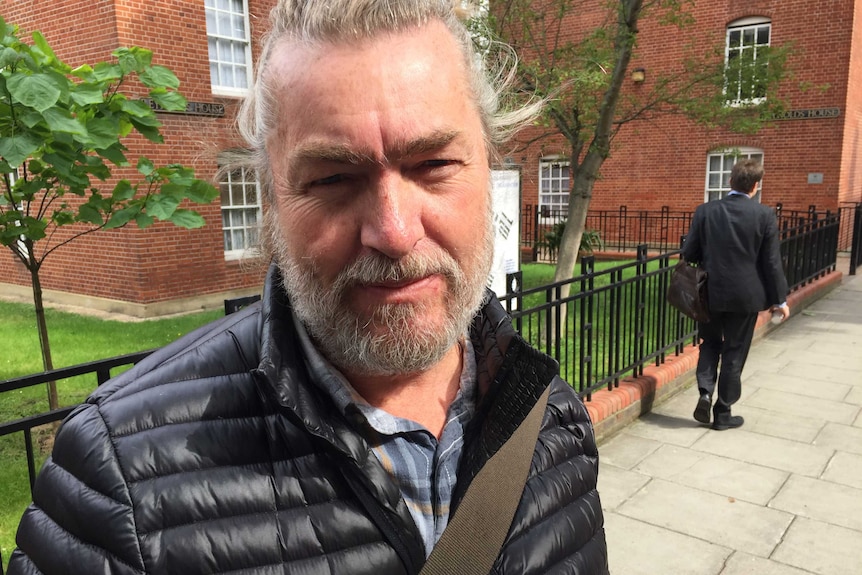 Voter Russell Thomas stands on the street in front of a polling station.