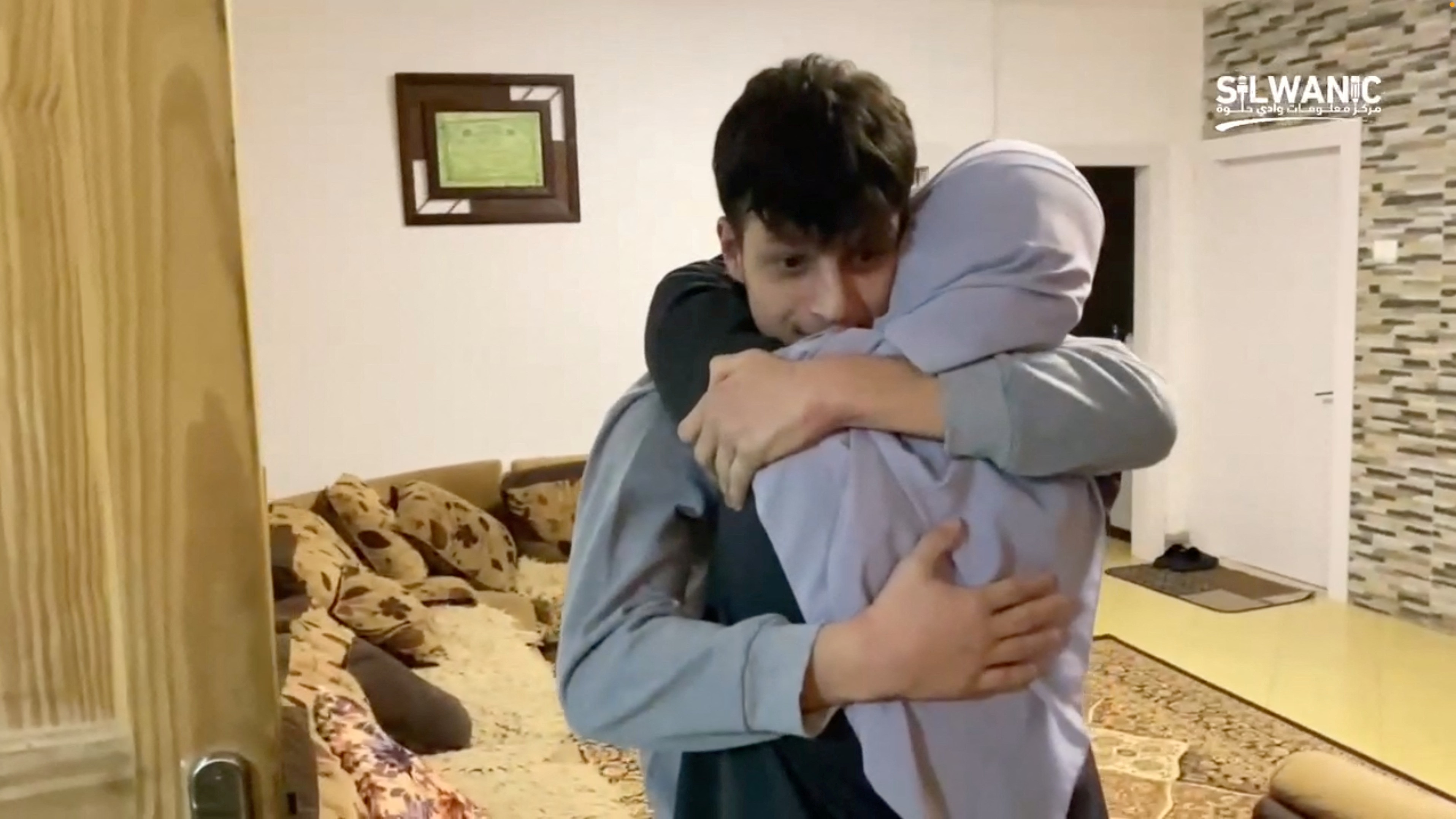 A young man hugging a woman. 